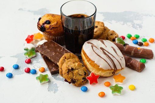 Unhealthy sweets and soda on a countertop.