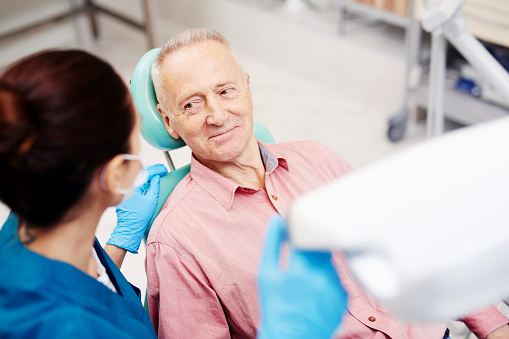 Mature man sitting in dental chair at Djawdan Center for Implants & Dentistry in Annapolis, MD